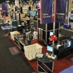 Engineering Innovation's trade show booth with several mail sorting machines.